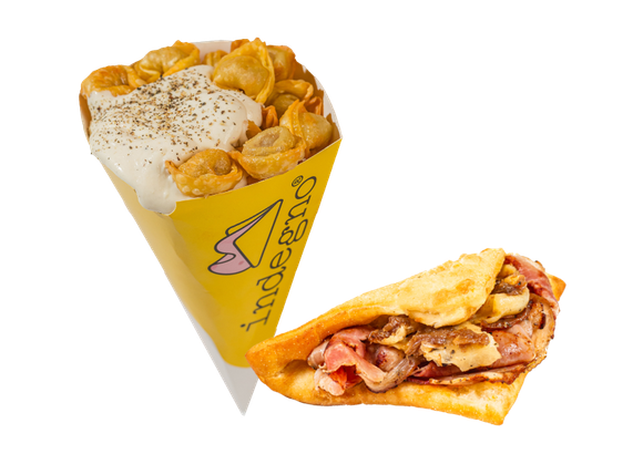 Un cono giallo ripieno di pasta condita con salsa bianca, accanto a una focaccia piegata e ripiena di salumi.