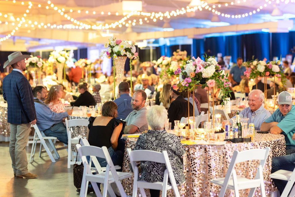 a large group of people are sitting at tables at a large event