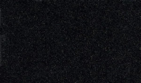 Dark, nearly black textured surface with faint speckles and grain.