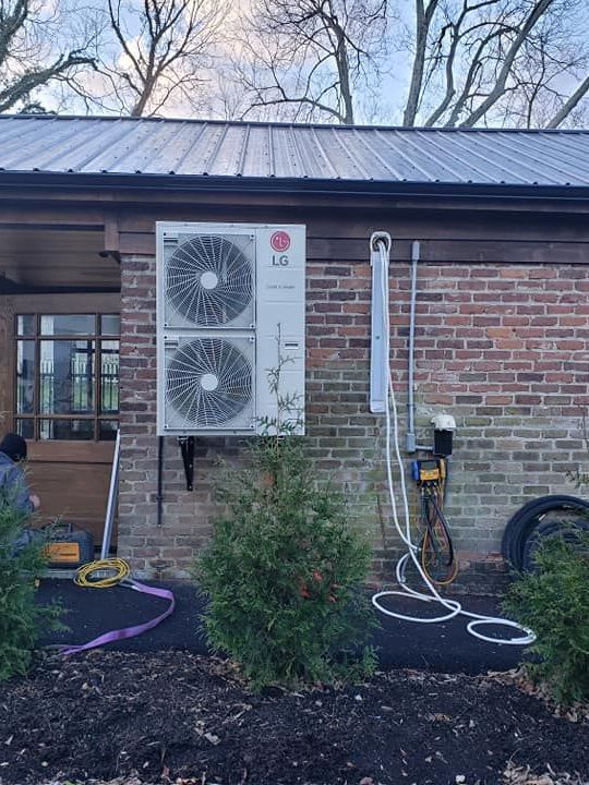 An lg air conditioner is installed on the side of a brick building.