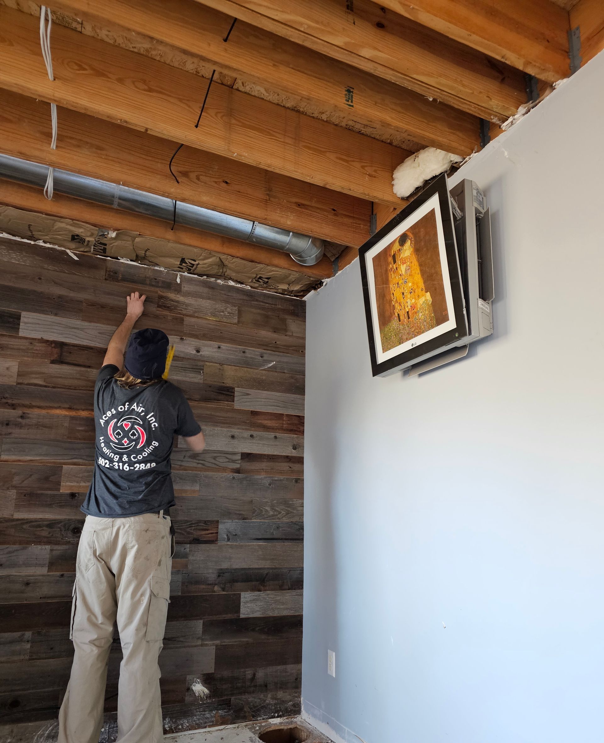 A man is working on duct sealing in a room.