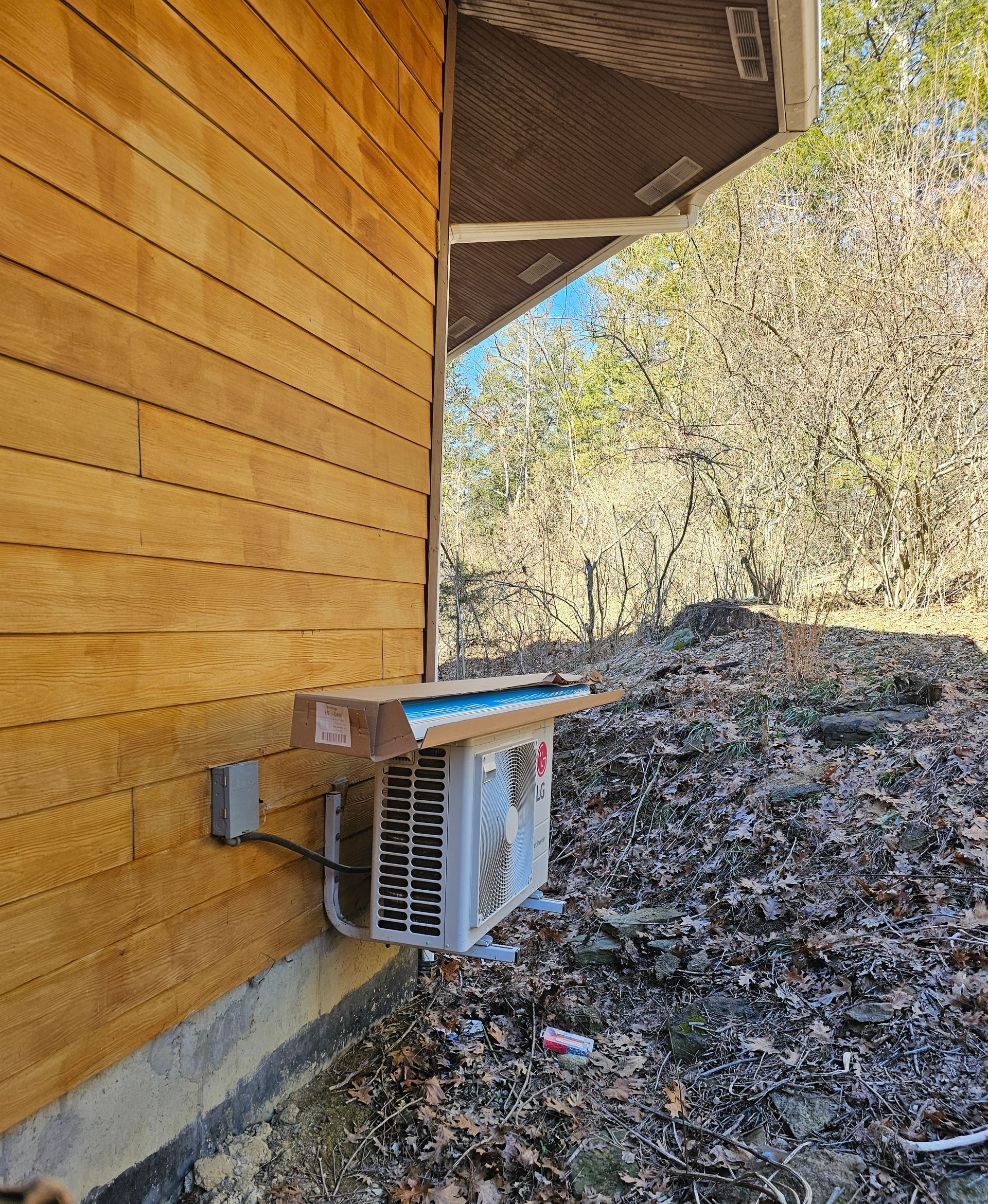 A box is sitting on the side of a wooden house.