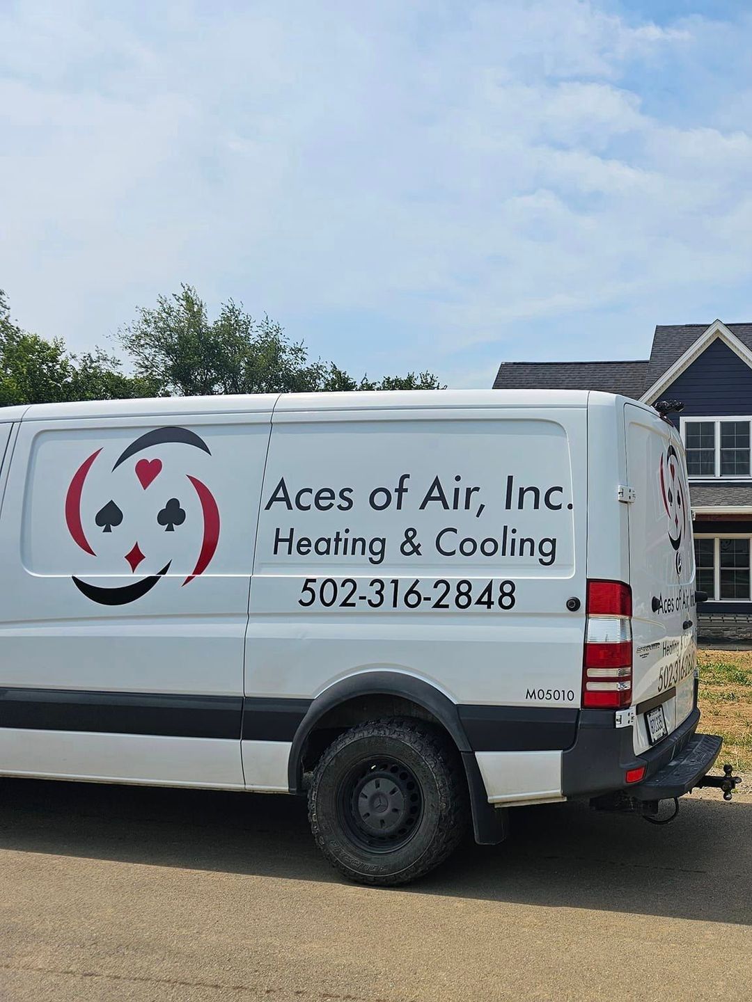 A white van is parked in front of a house.