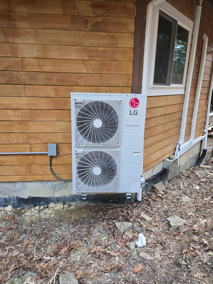 An lg air conditioner is sitting on the side of a wooden house.
