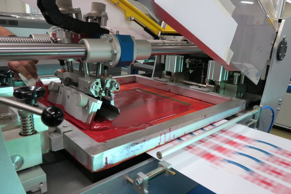 A Person Is Working on A Machine that Is Printing a Piece of Paper — Imsprint in East Maitland, NSW