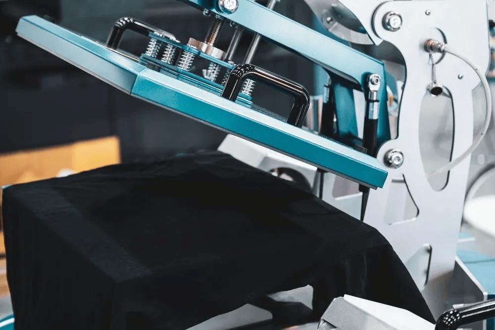 A Machine Is Printing a Black Shirt on A Table — Imsprint in Lake Macquarie, NSW
