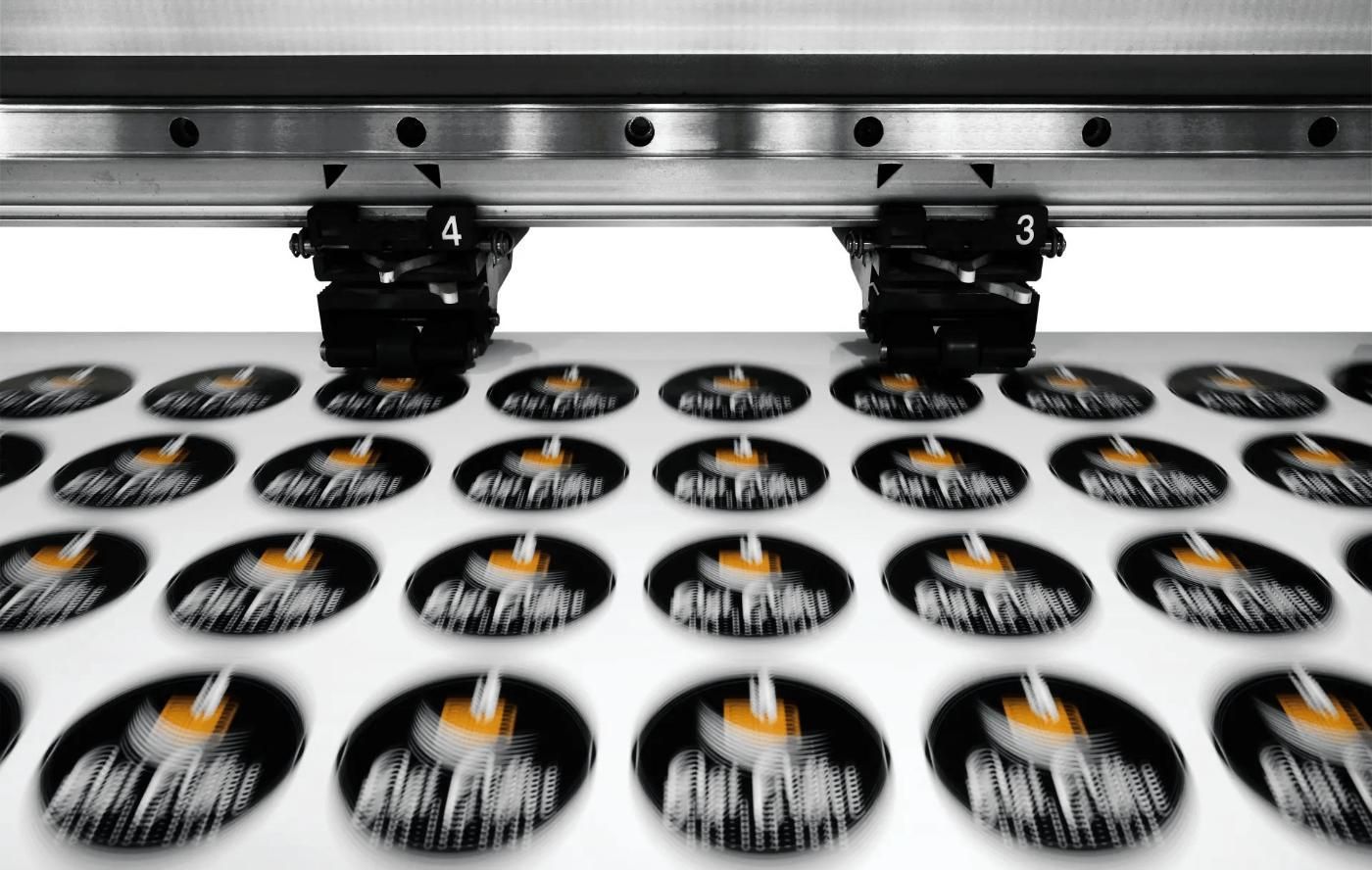 A Machine Is Printing Stickers on A White Surface — Imsprint in East Maitland, NSW