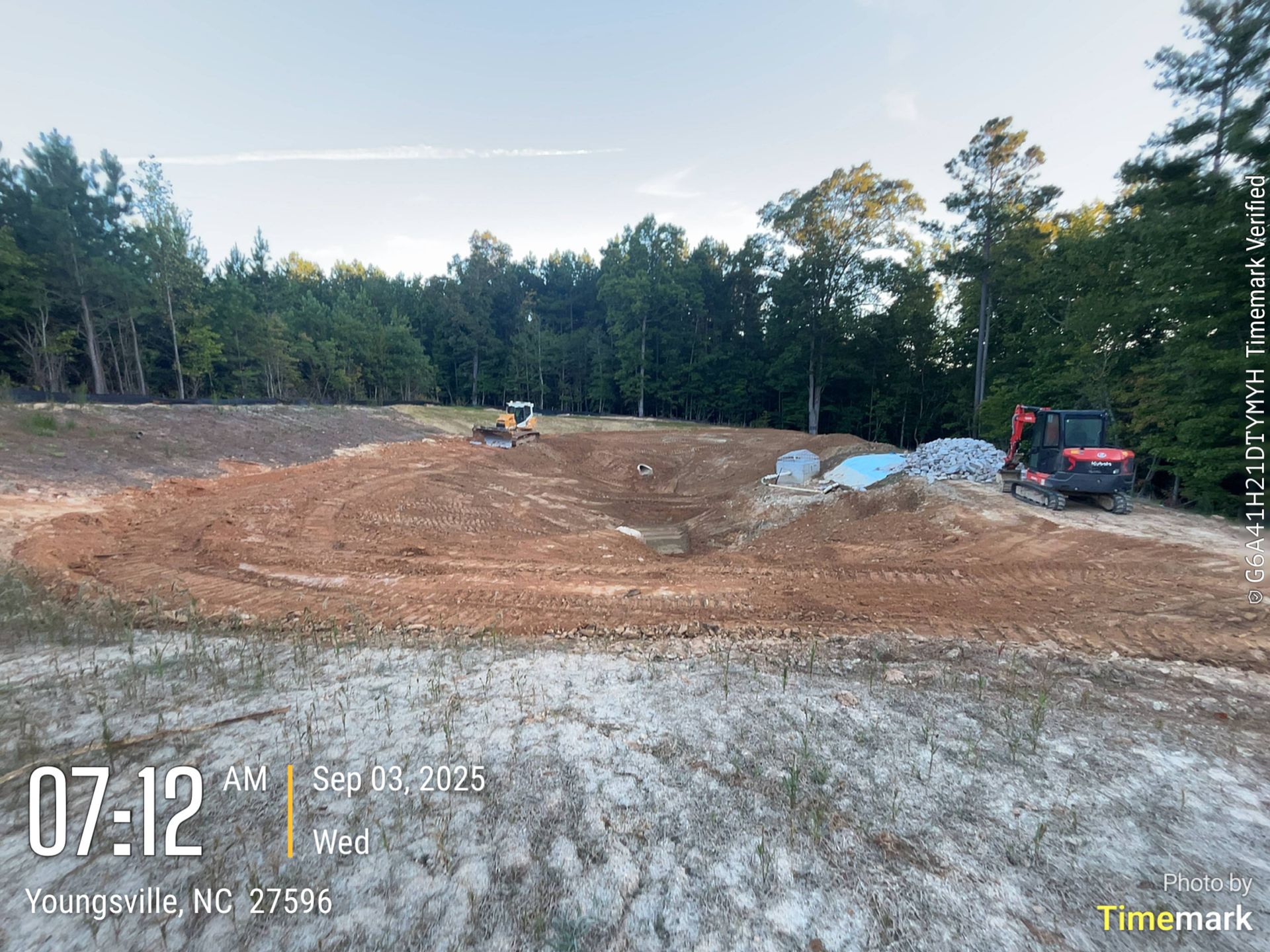 Construction site: Earth-moving equipment, trees, and a cleared area of dirt. Youngsville, NC.