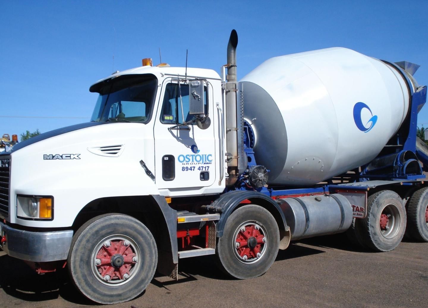White Concrete Mixer Truck With a Large Drum and Blue Accents — Ostojic Group in Berrimah, NT