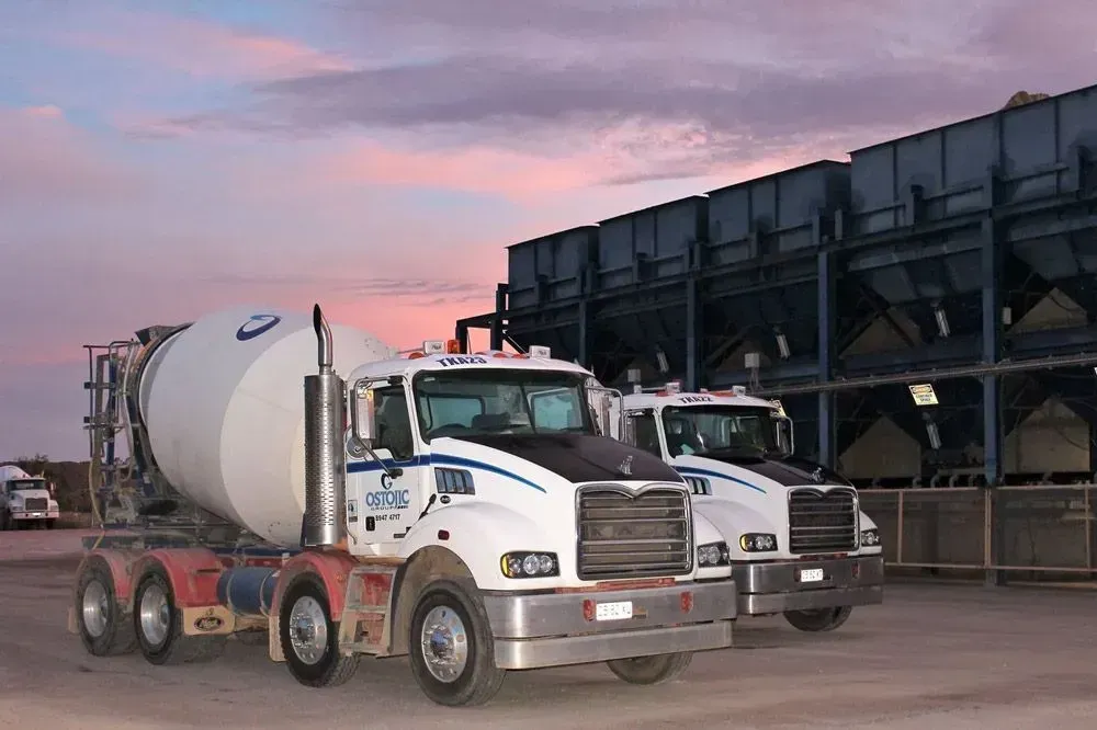 Two Cement Trucks Are Parked Next to Each Other in Front of a Building — Ostojic Group in Berrimah, NT