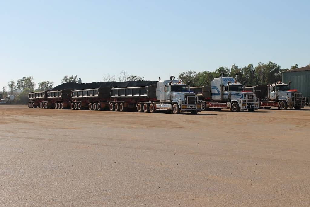 A Row of Semi Trucks Are Parked in a Dirt Lot — Ostojic Group in Berrimah, NT