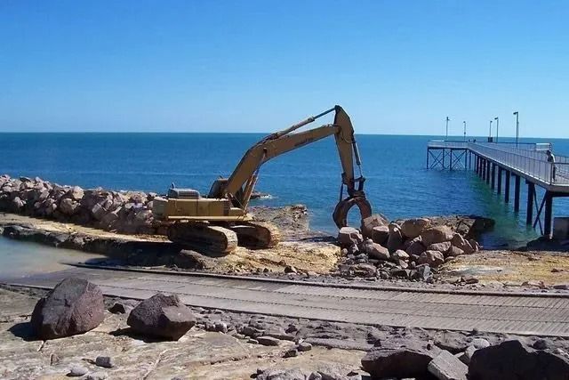 Rocks are being hauled next to a jetty and water — Ostojic Group in Berrimah, NT 