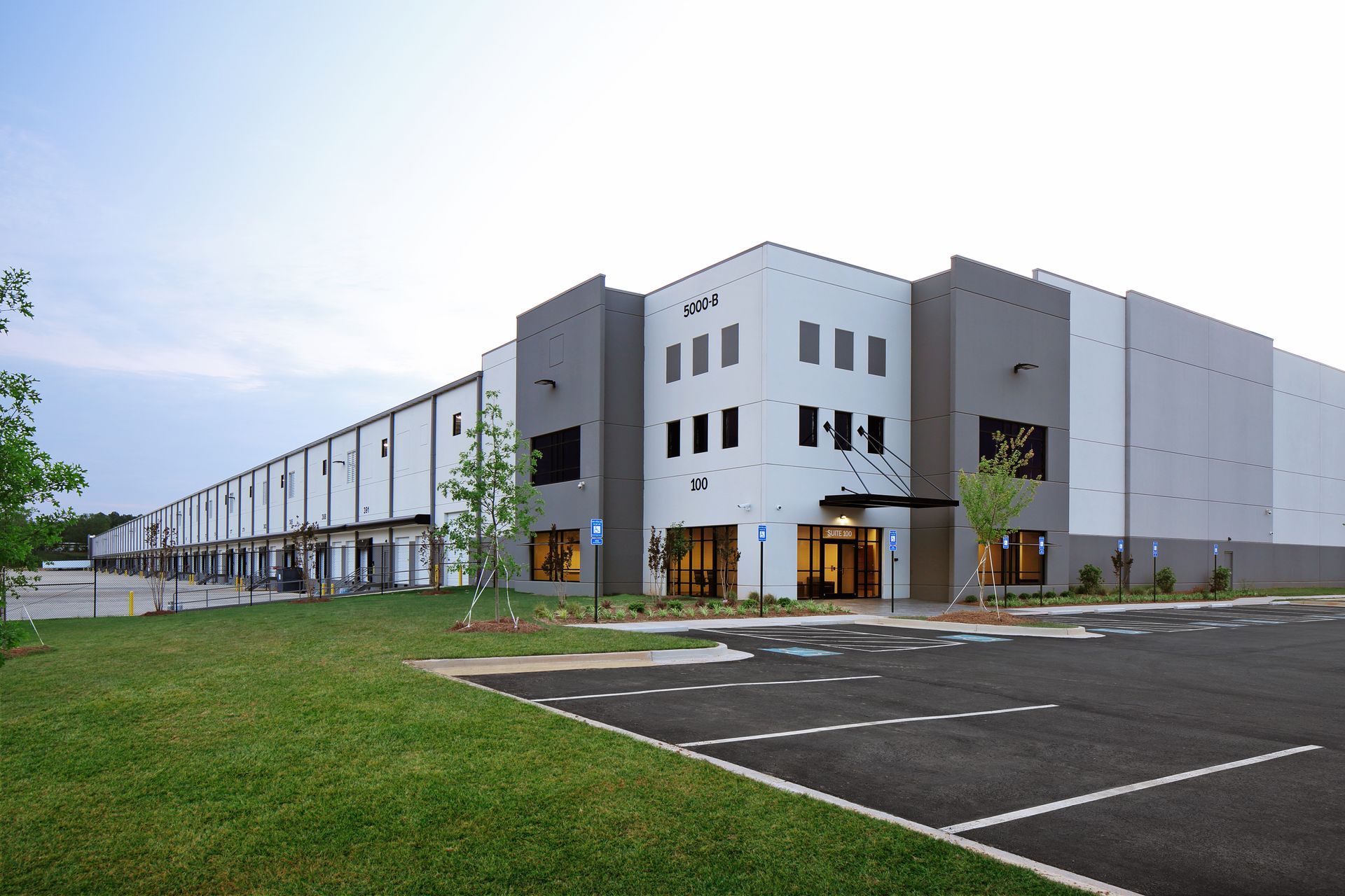 A large white building with a parking lot in front of it.
