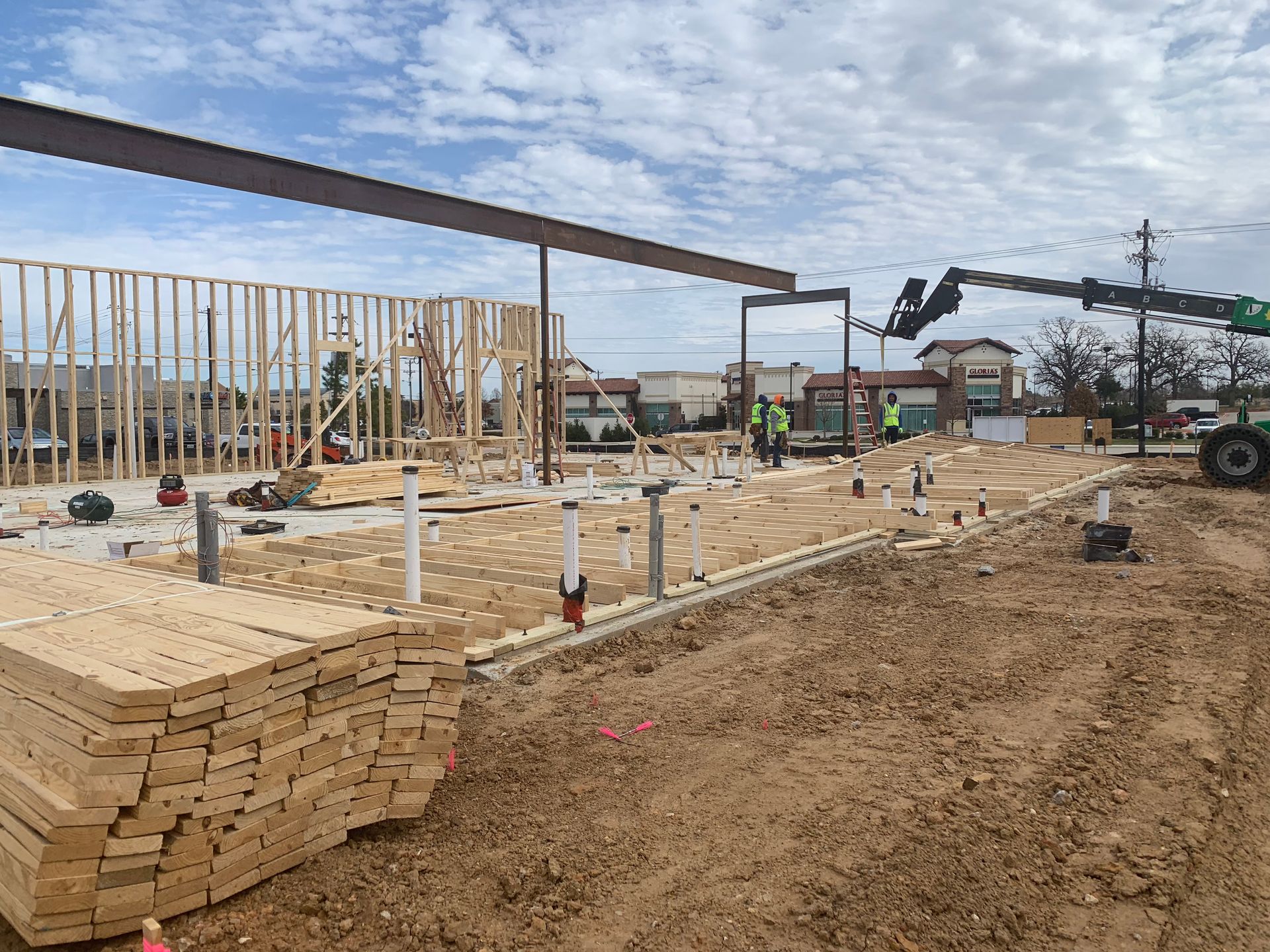 A construction site with a stack of wood and a crane.