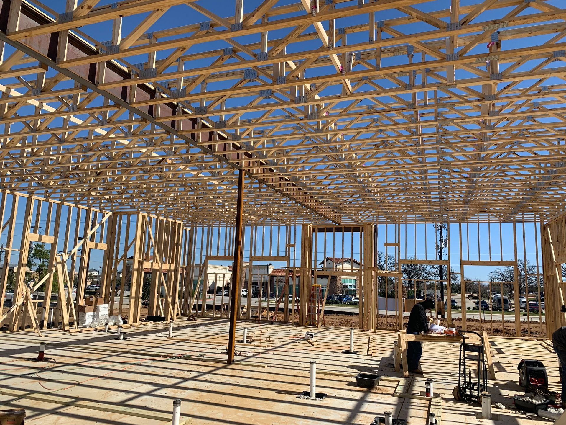 A large wooden structure is being built on a sunny day.