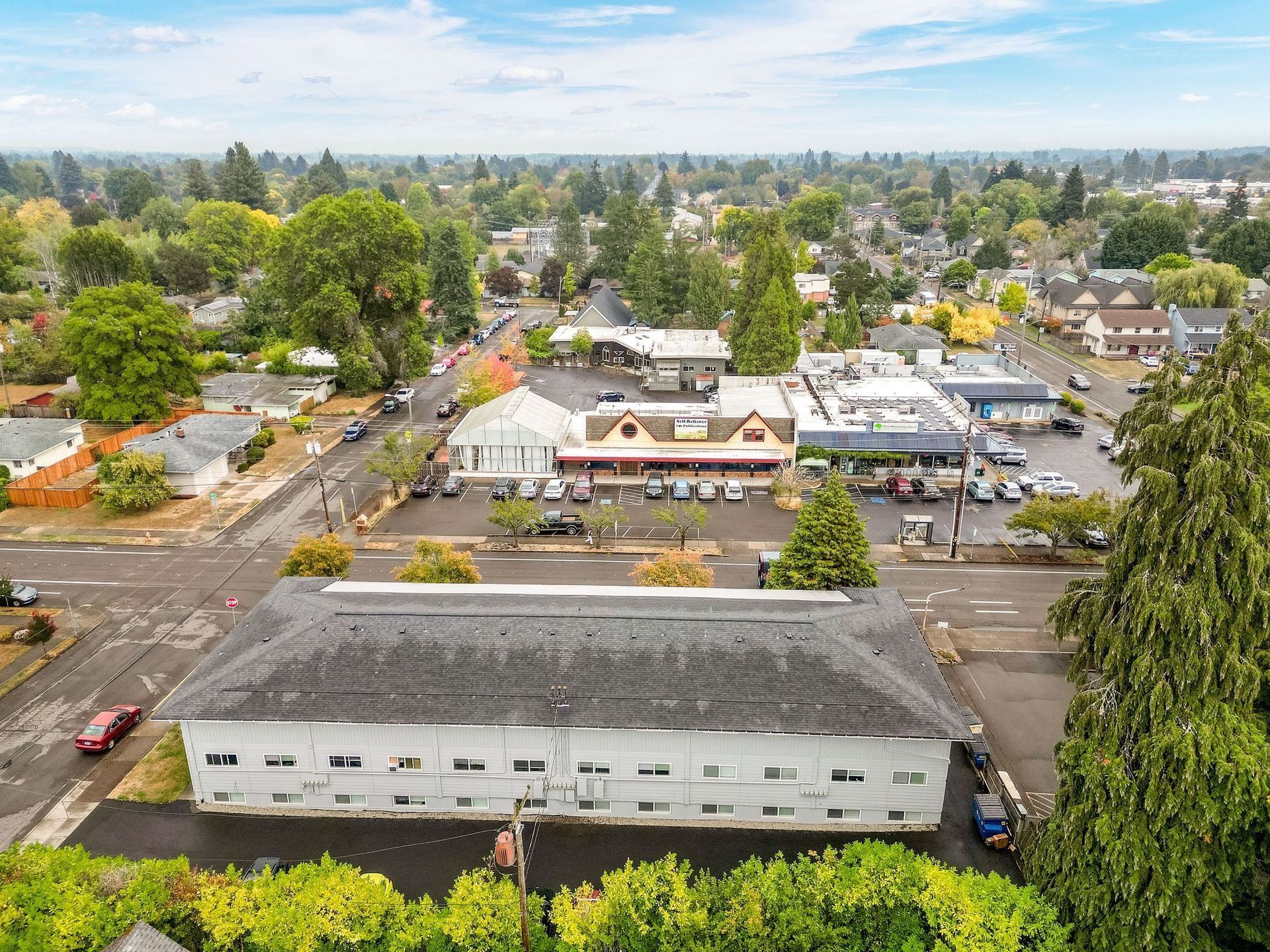 Aerial view of a small town with streets, buildings, trees, and a cloudy sky
