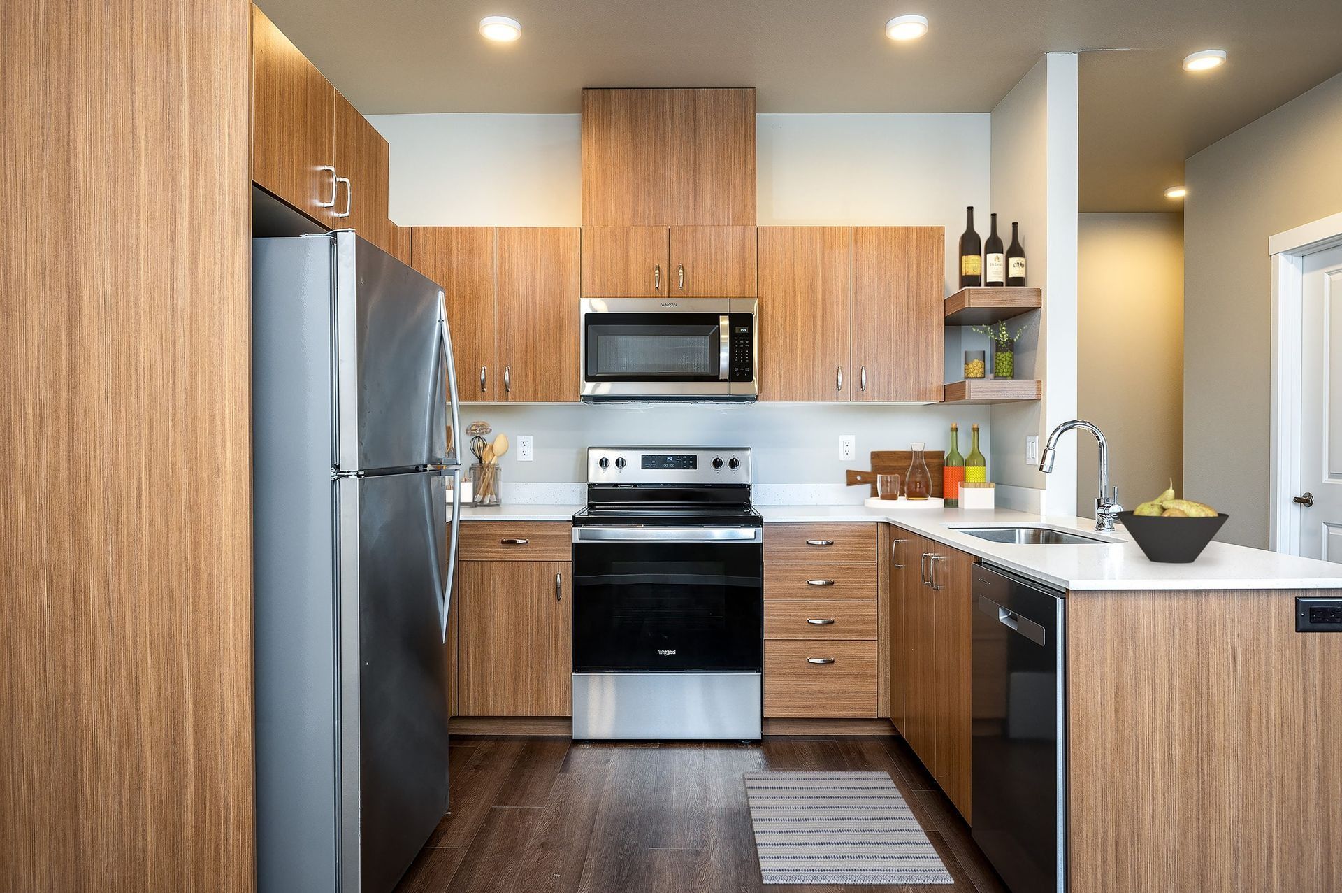 Modern kitchen with wood cabinets, stainless steel appliances, and a dark island countertop