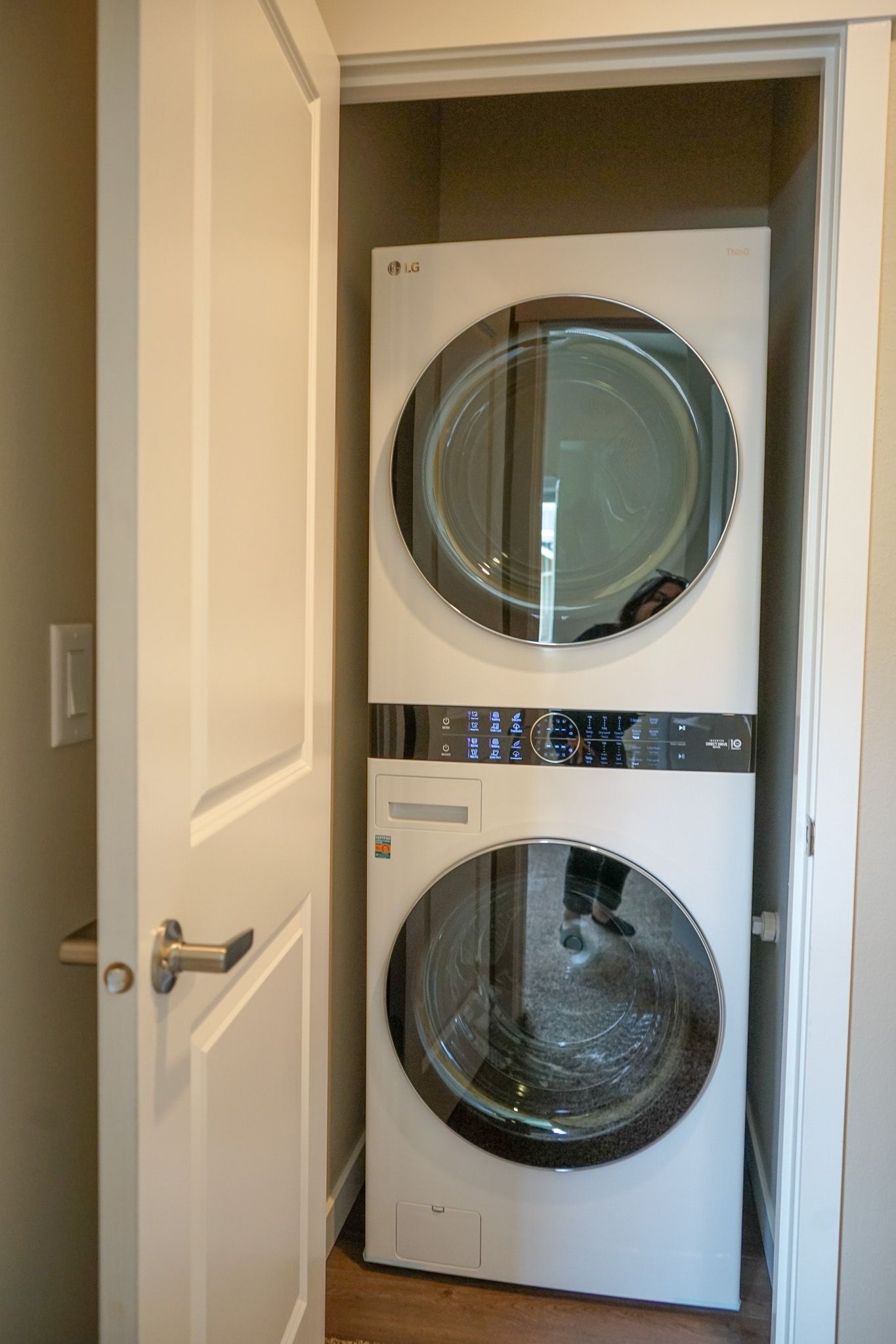 Stacked washer and dryer in a small laundry closet with the door open