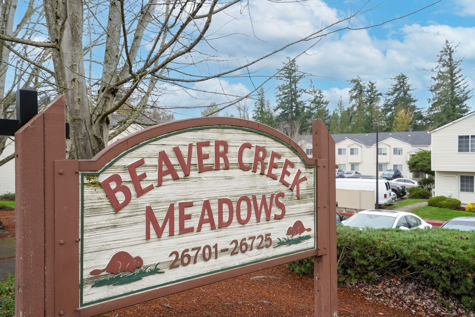 Beaver Creek Meadows entrance sign in front of apartments and trees