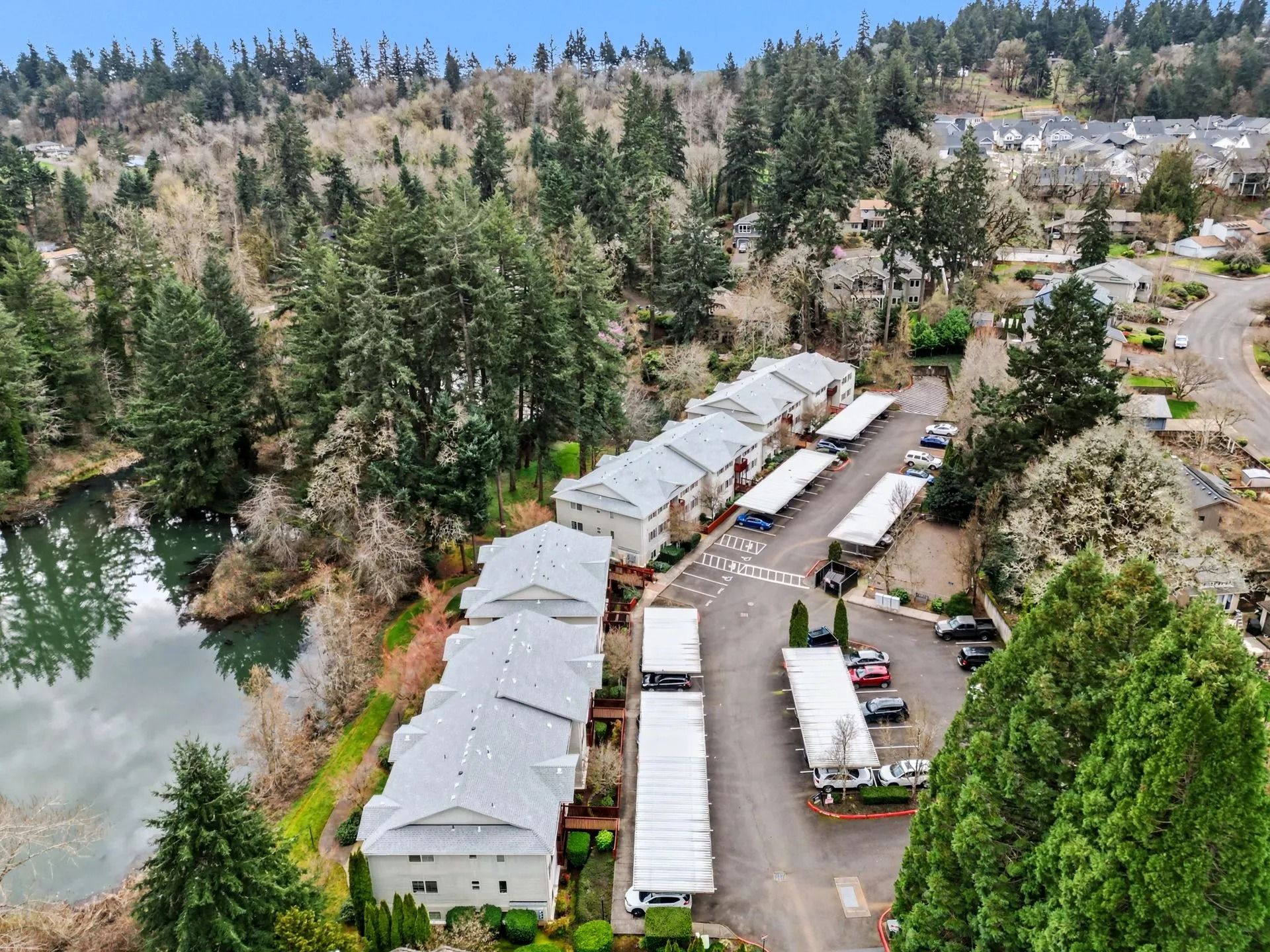 Aerial view of a lakeside mobile home park surrounded by trees and forested hills