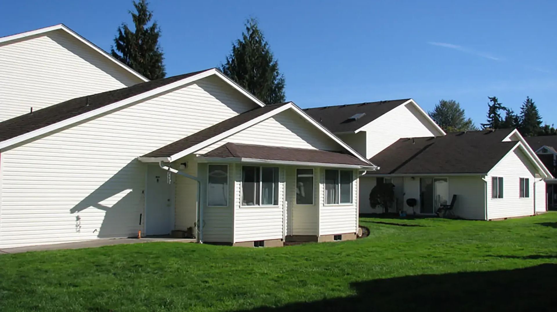 White suburban houses with green lawns on a sunny day