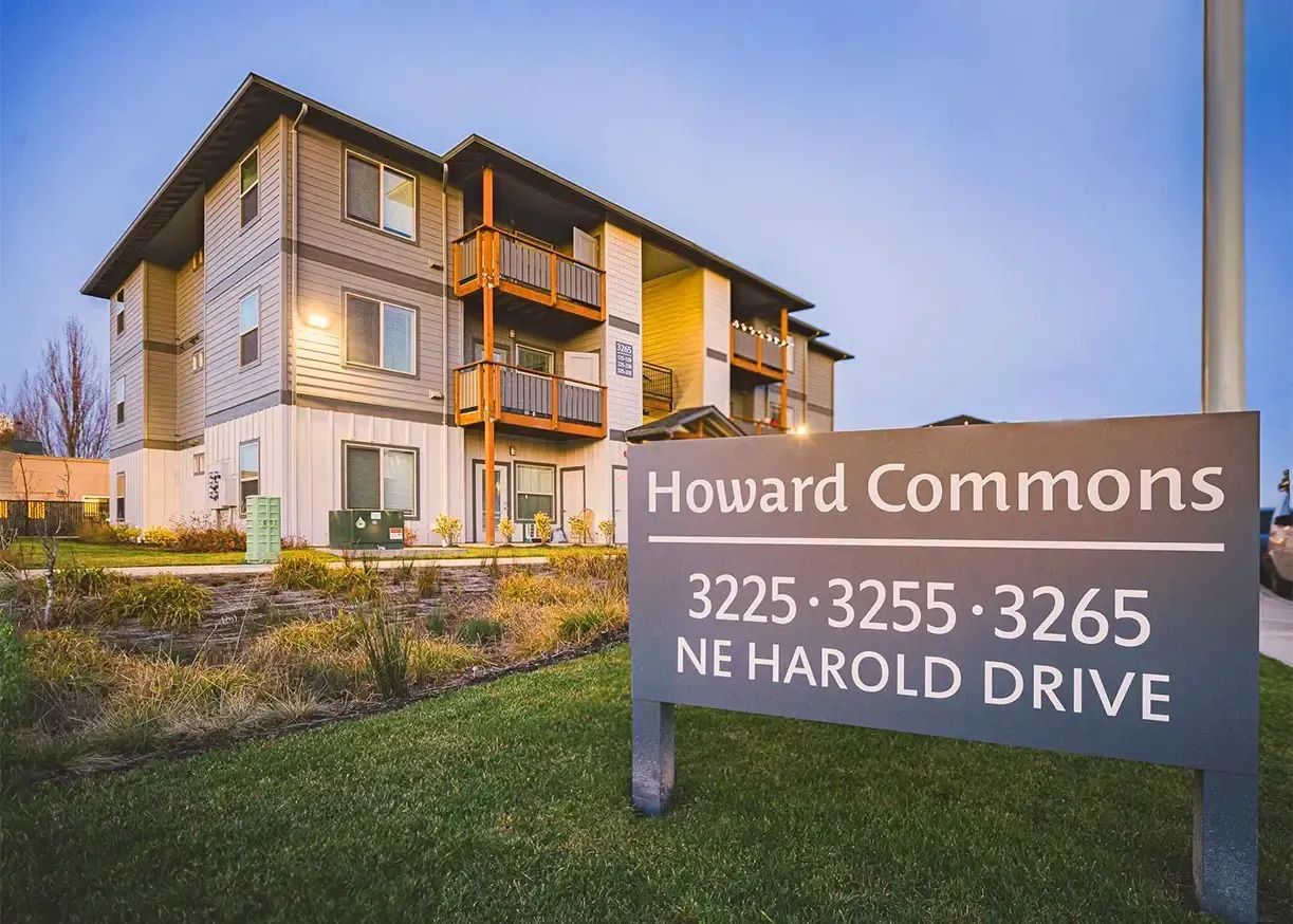 Howard Commons apartment building with sign reading “3225-3265 NE Harold Drive” at dusk