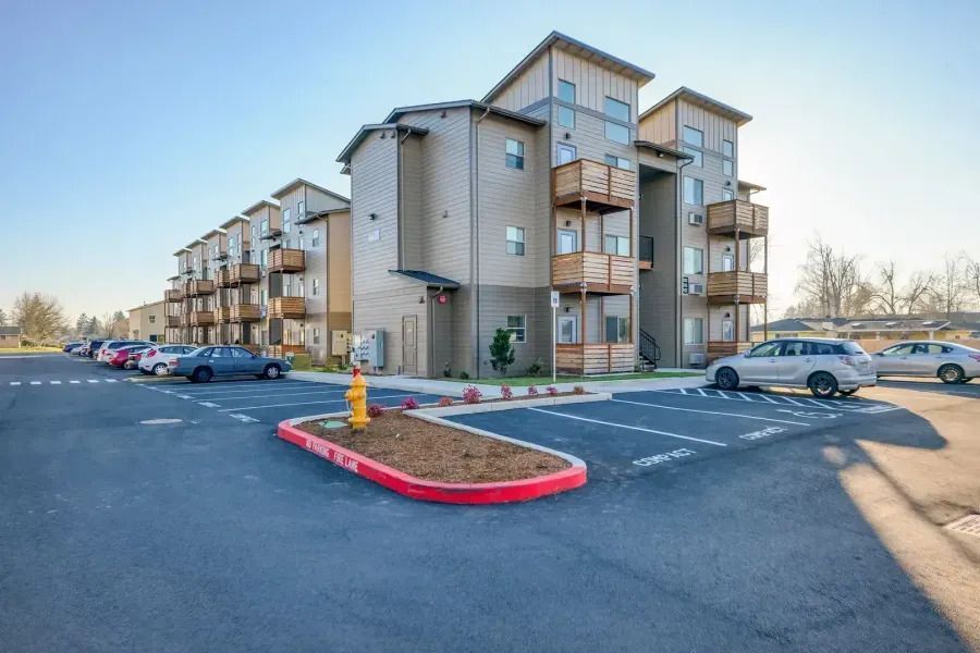 Apartment complex parking lot with parked cars and a red-brick island