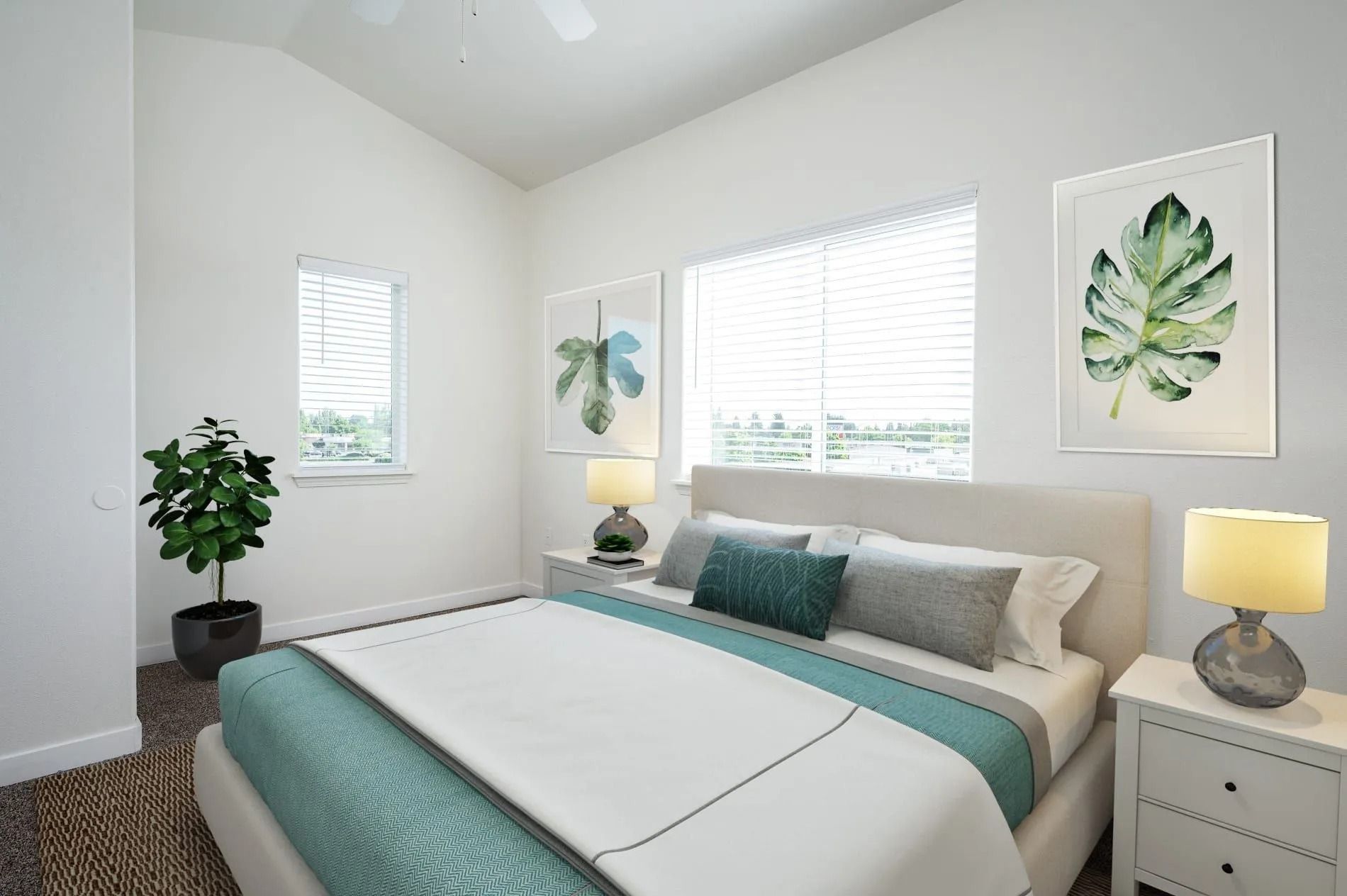 Bright bedroom with teal bedding, white walls, and framed leaf art by a window