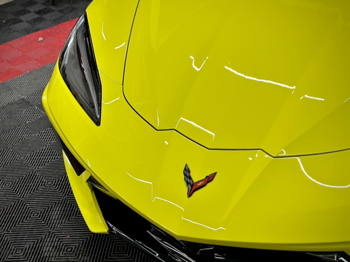 Close-up of a yellow Corvette with Paint Protection Film (PPF) on the front.