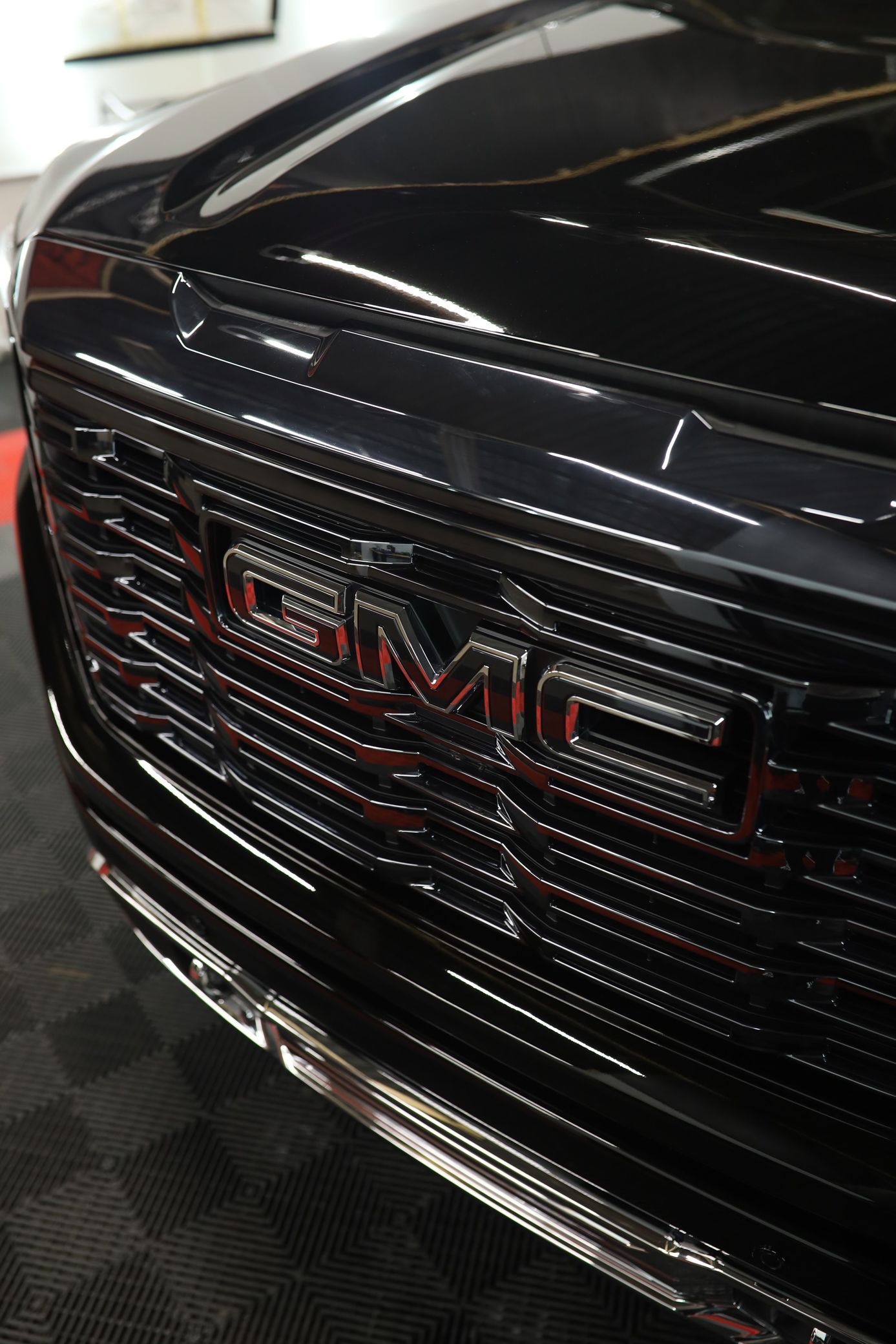 A black gmc truck is parked in a garage