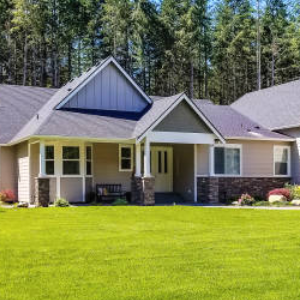 A large house with a lush green lawn in front of it.