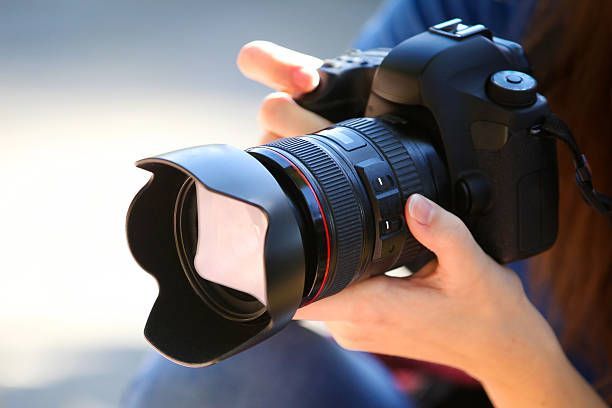 A woman is holding a canon camera in her hands.