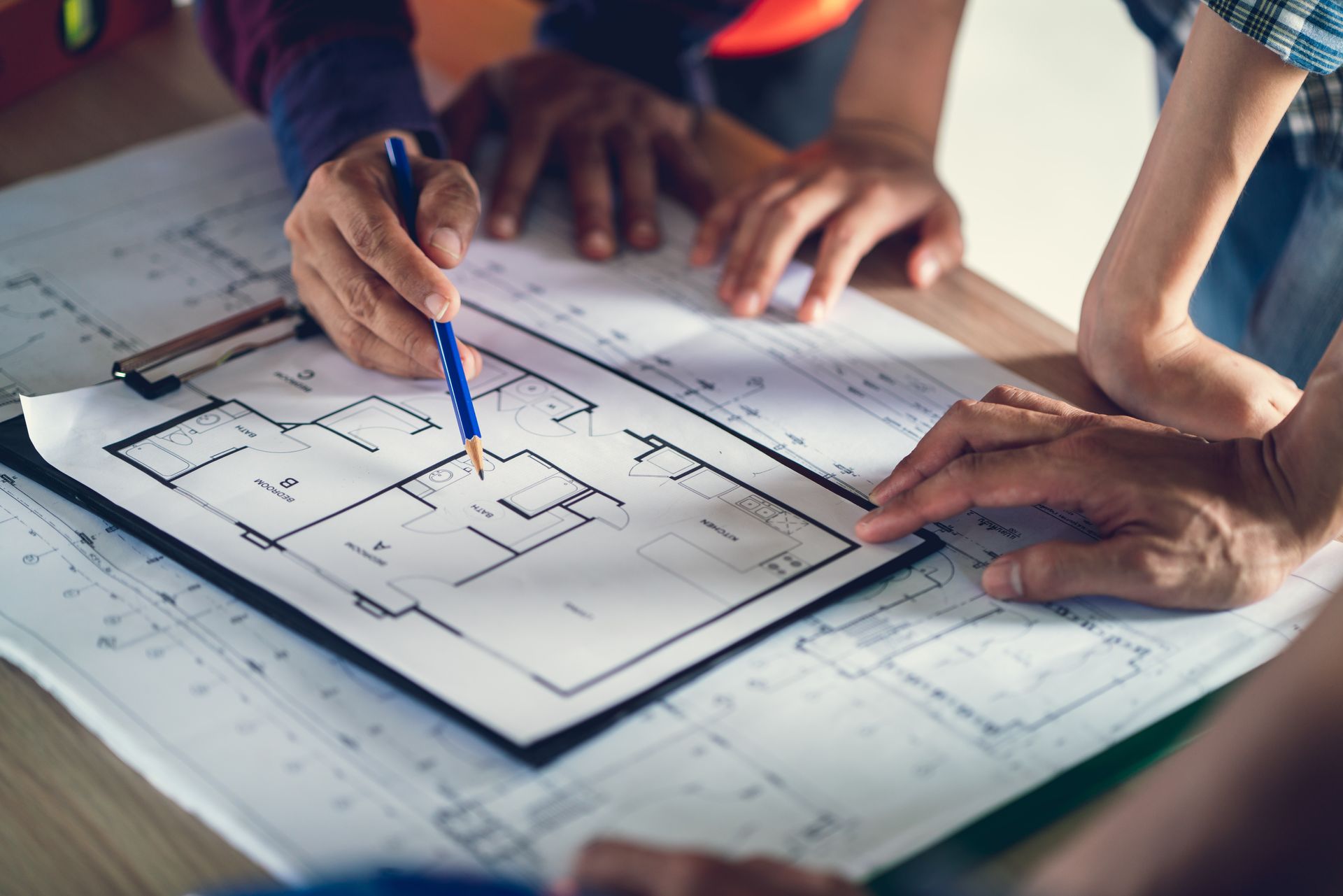 Architects & engineers working with a blueprint of a home construction. Architects & engineers working with a blueprint of a home construction.