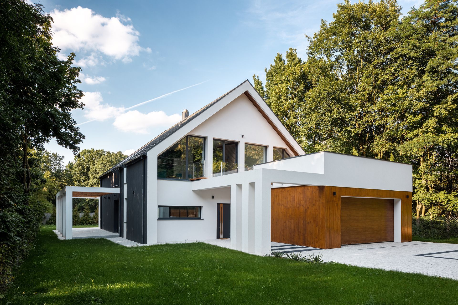 View of a modern, white house with a garage, showcasing expert new home design.