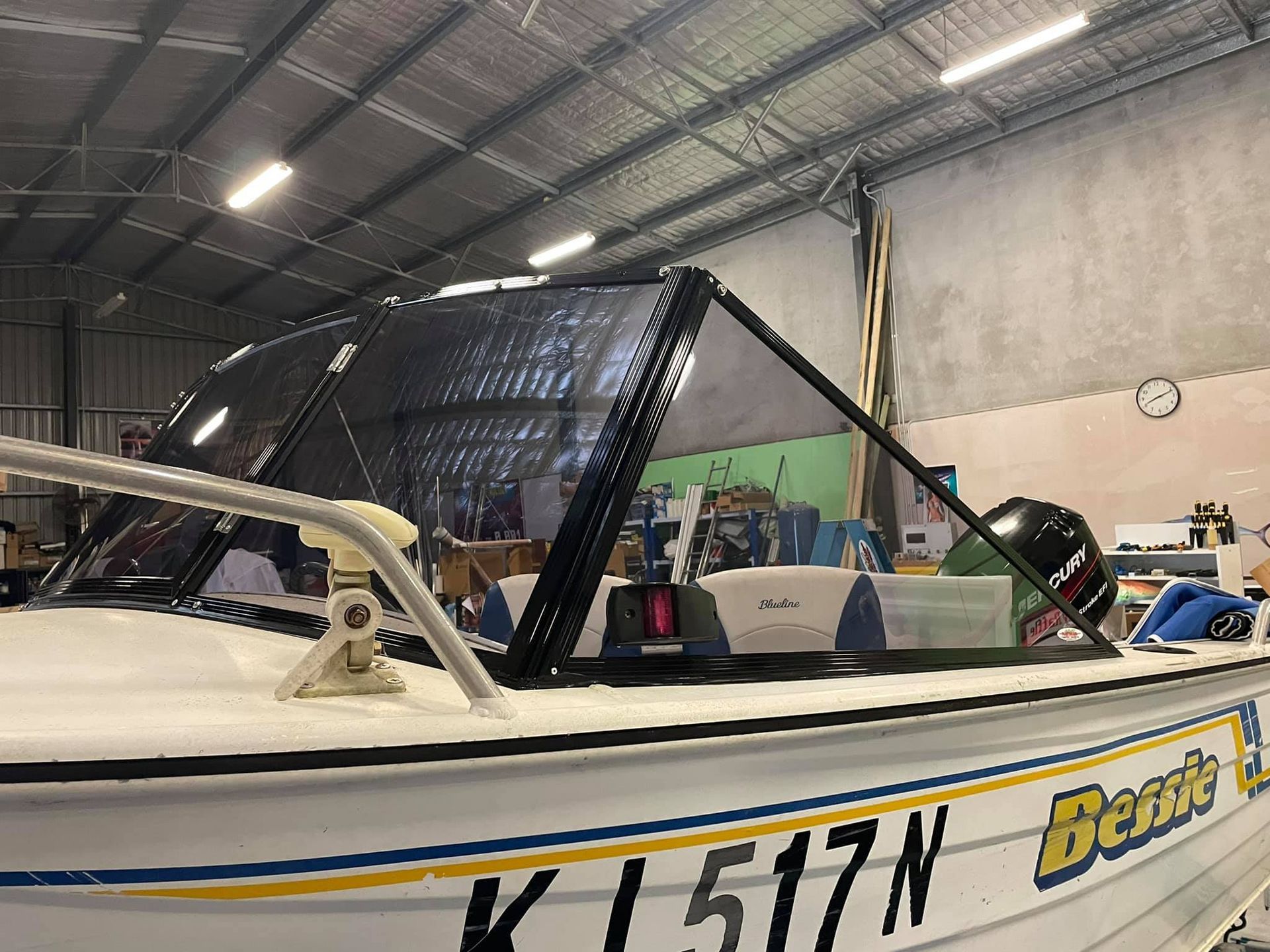 A boat with the number 517n on the side is sitting in a warehouse - Plastiglass Mid North Coast, NSW