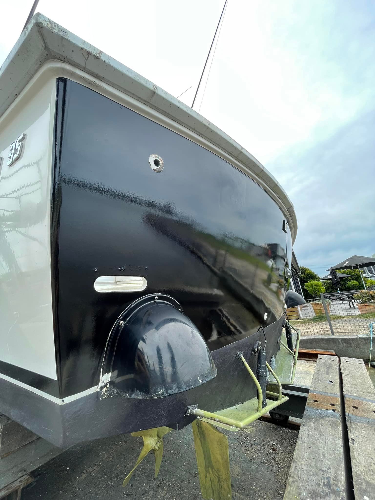 A black boat is getting wrapped - Plastiglass Mid North Coast, NSW