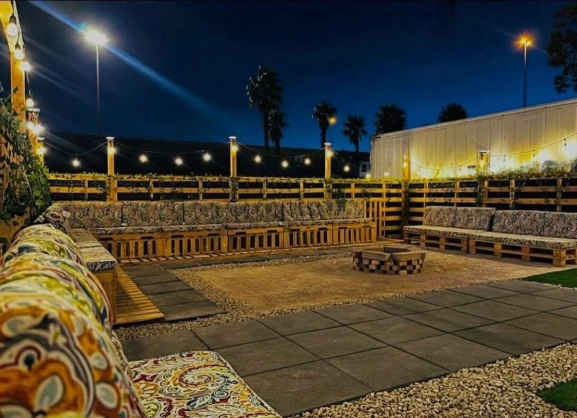 Nighttime outdoor amphitheater with patterned seating, stage, and warm lights under a dark blue sky