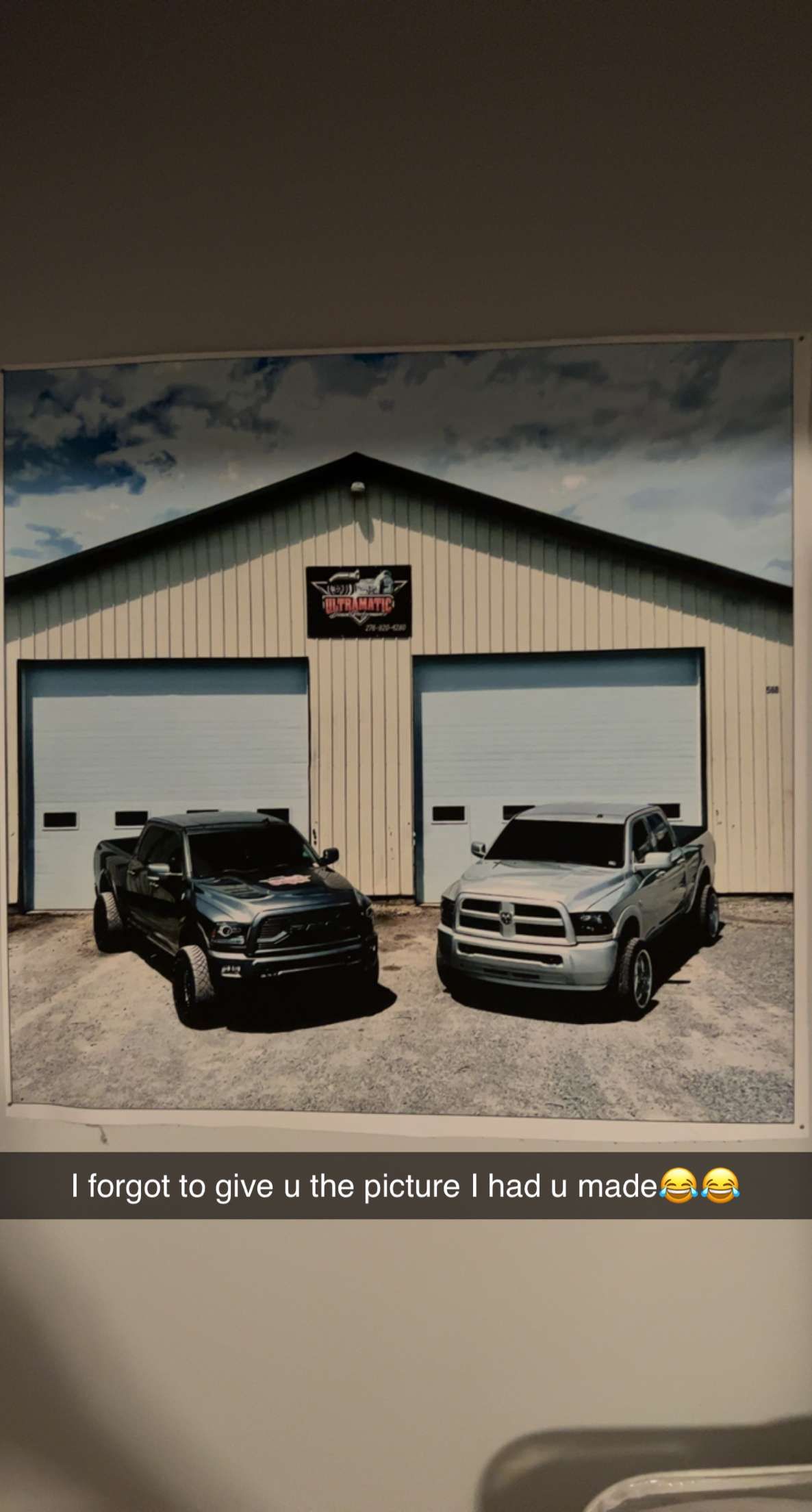 A picture of two cars parked in front of a garage.
