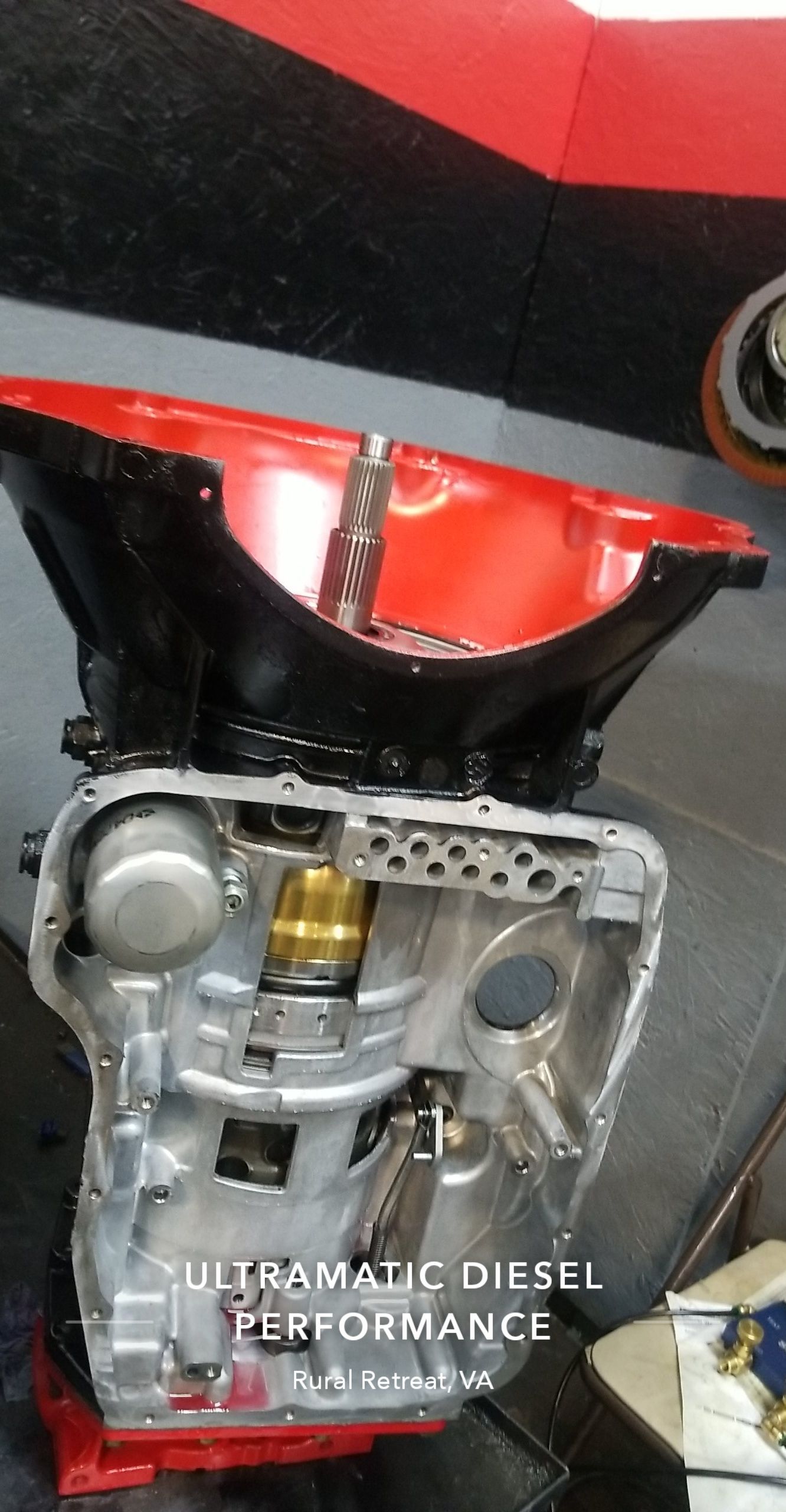 A close up of a car engine with a red bowl on top of it.