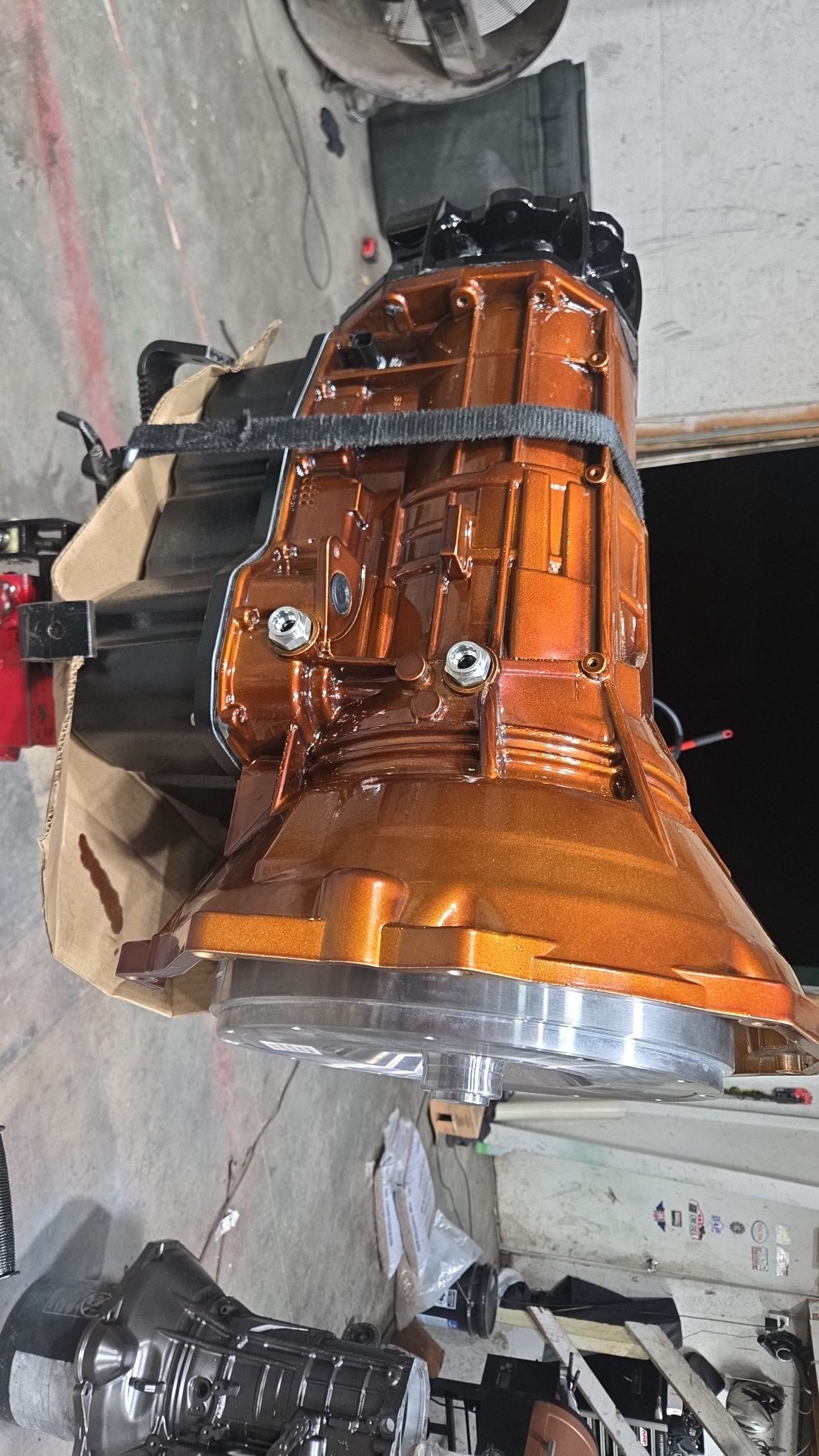 A large engine is sitting on top of a table in a garage.