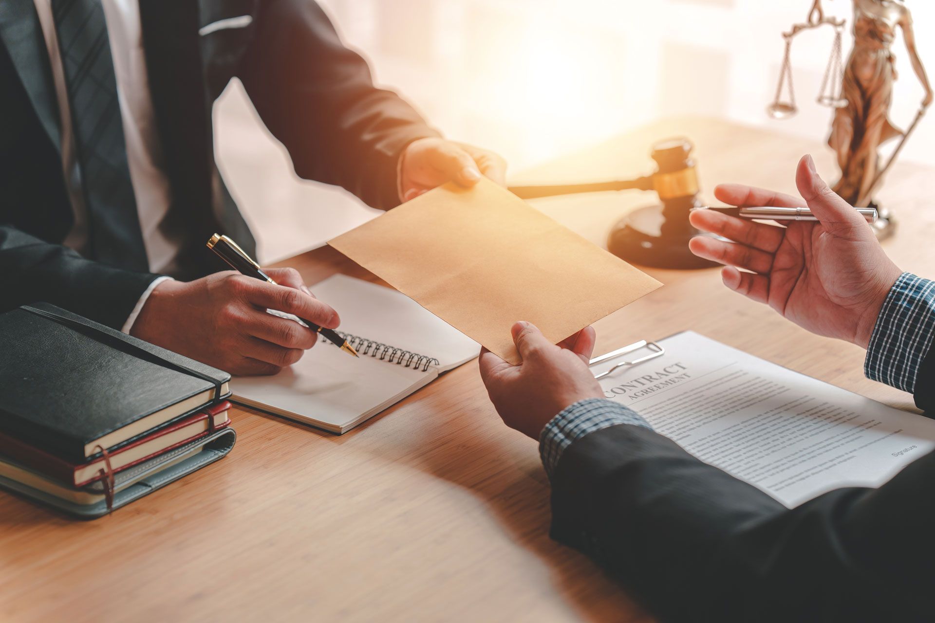 People in business attire reviewing documents and taking notes around a sunlit meeting table
