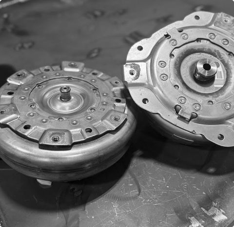 Two metal mechanical clutch assemblies on a workbench, shown in grayscale. | G3 Transmission and Auto