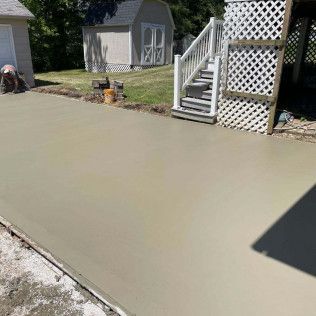 A Man Is Working On A Concrete Driveway — Evansville, IN — Red Beaver Construction