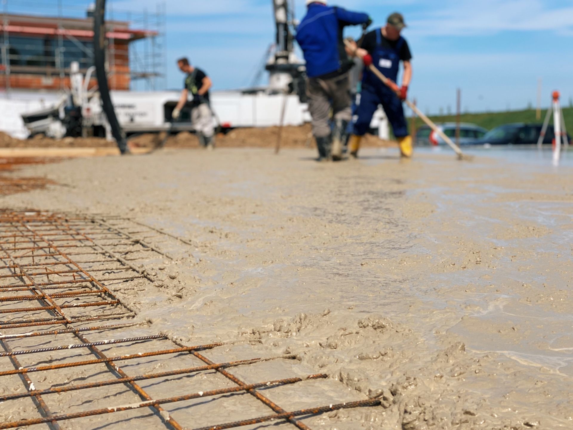 Red Beaver Construction workers leveling a concrete pad at a residential site.