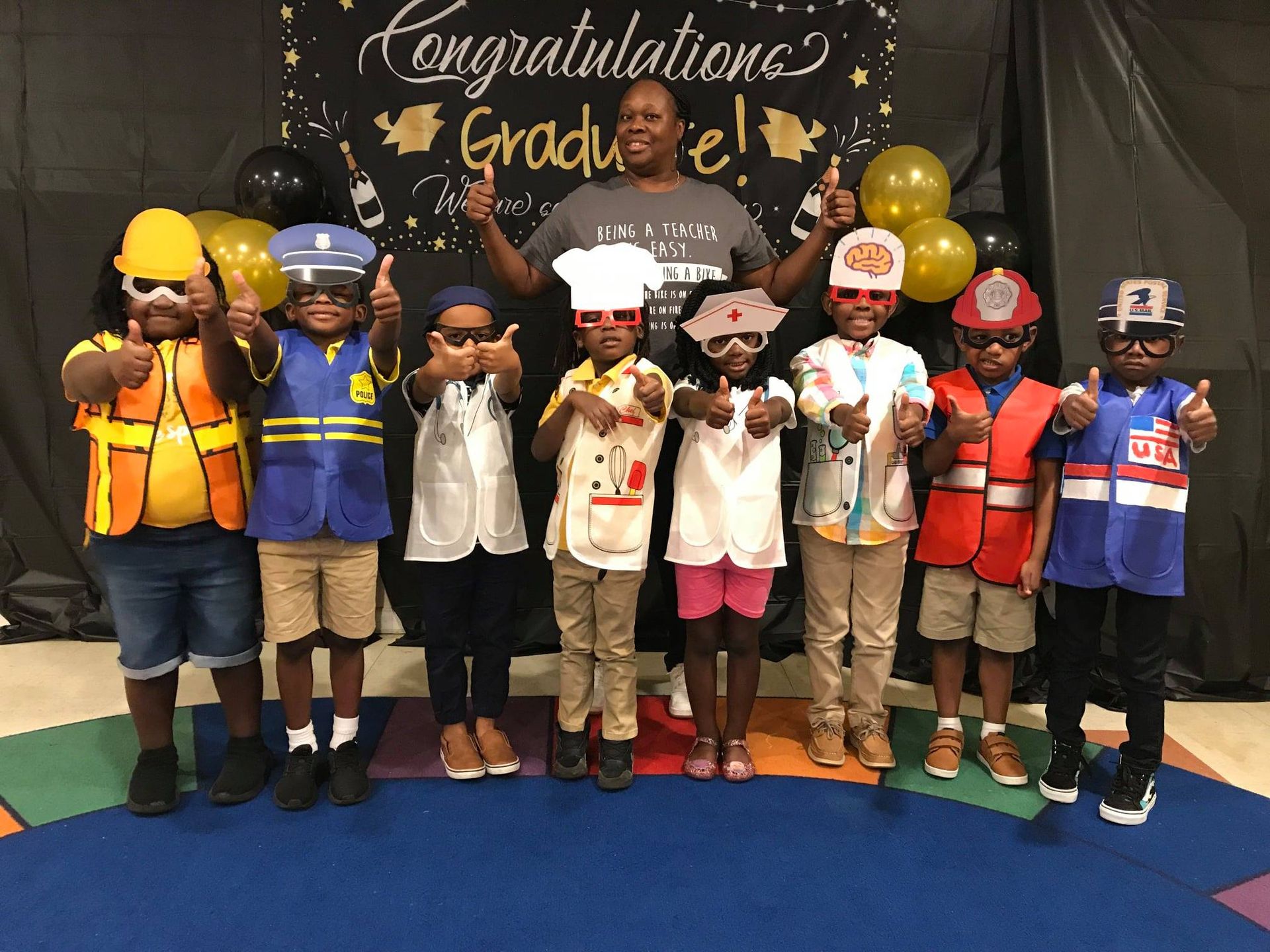 A group of children are standing in front of a sign that says congratulations graduate.