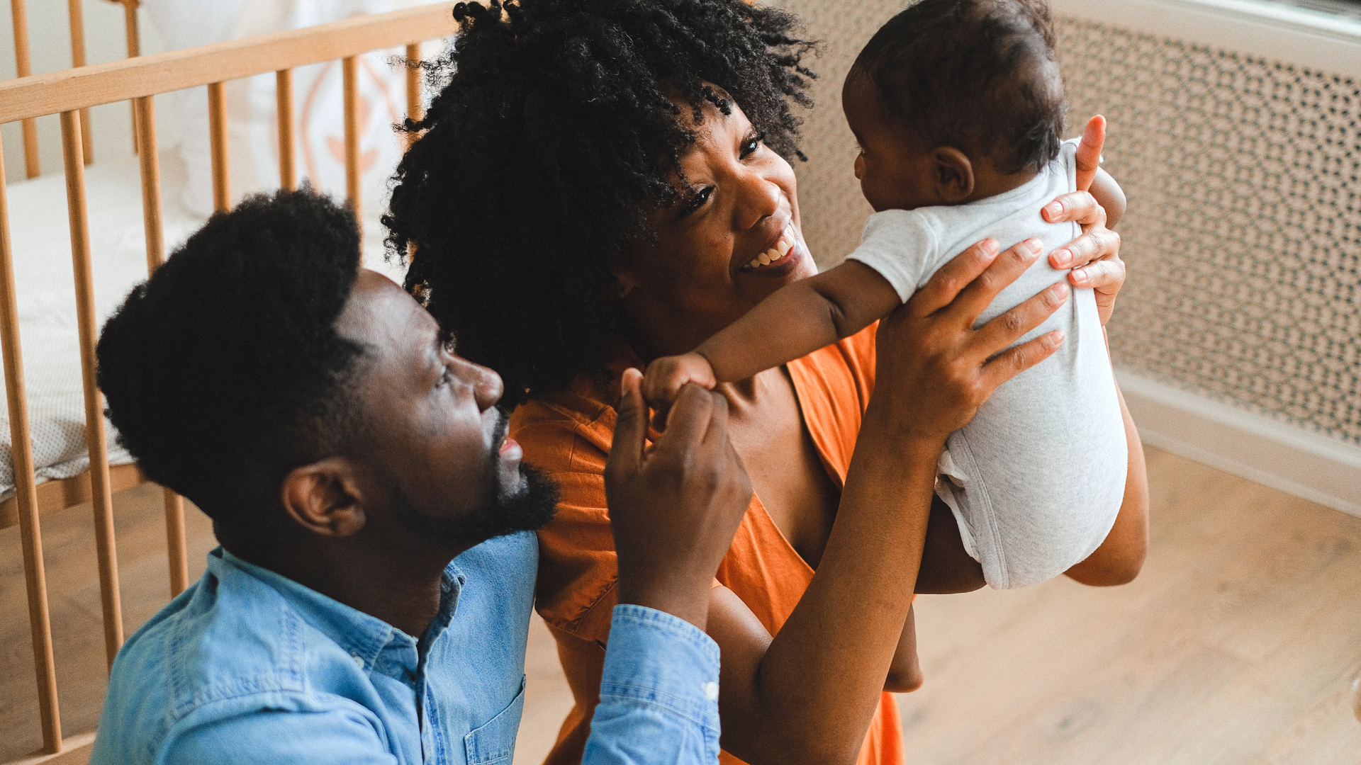 A man and a woman are holding a baby in their arms.