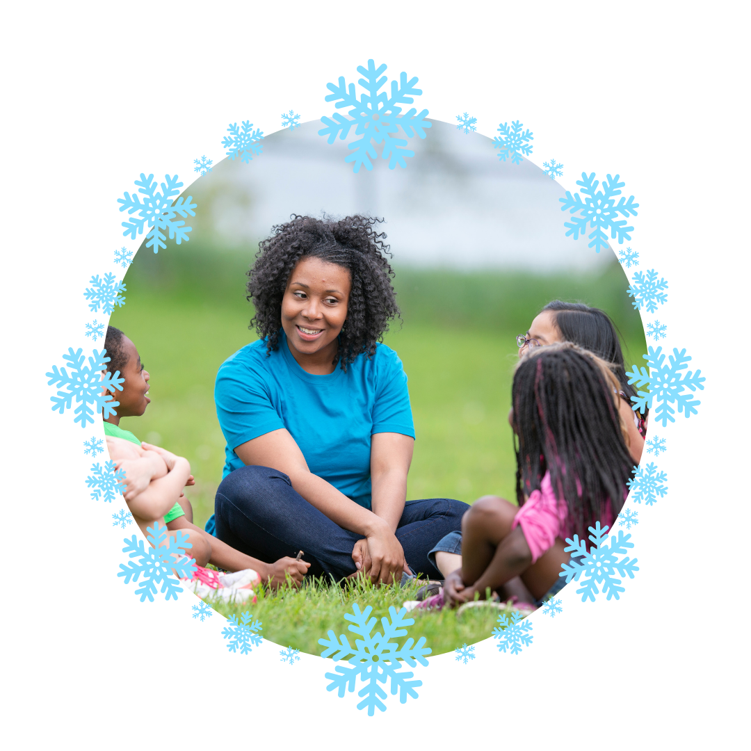 A woman is sitting in the grass with a group of children.