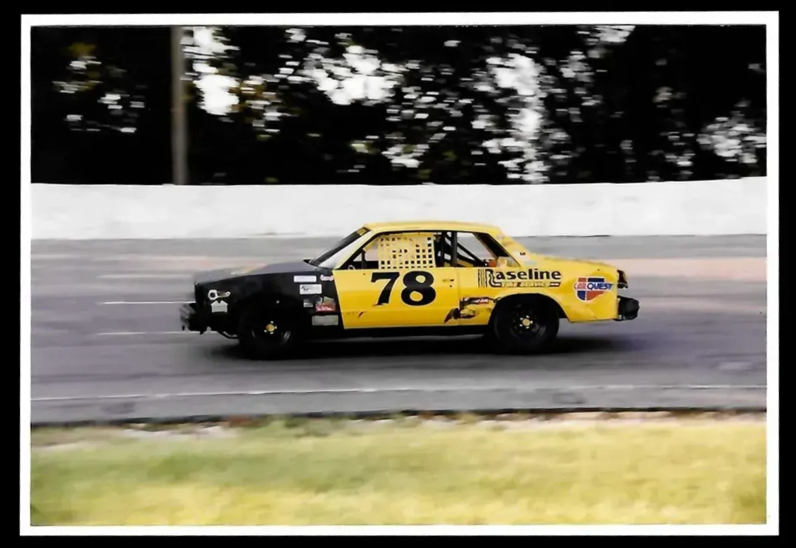 Yellow stock car #78 racing around a track; black front end, blurred background.