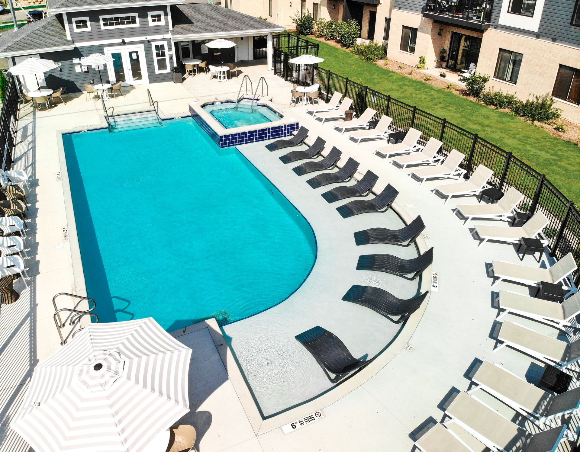 An aerial view of a large swimming pool surrounded by chairs and umbrellas.