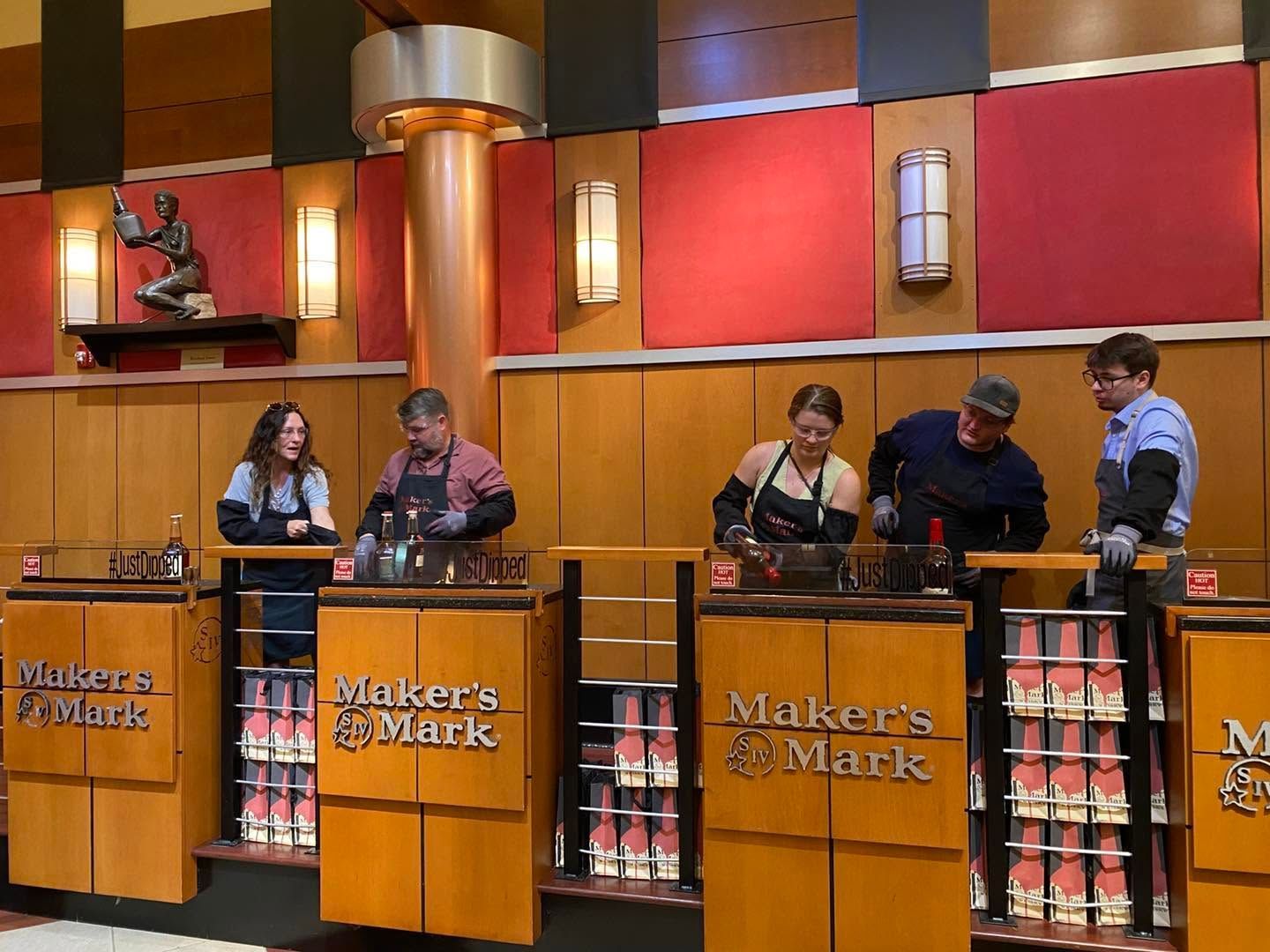 Five people cooking at a Makers Mark bar in a brightly lit kitchen studio